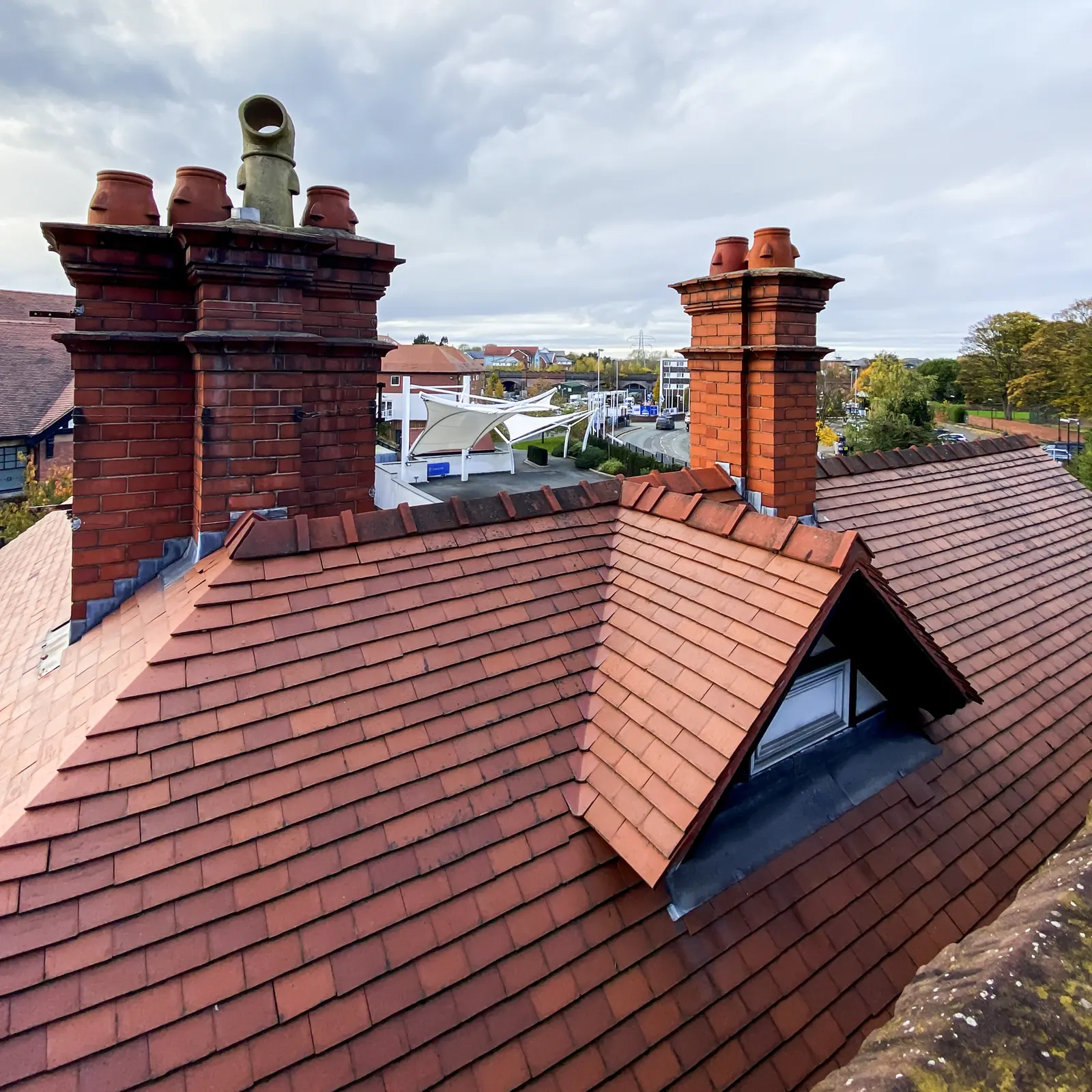 Chimneys and a dormer on a red tile roof