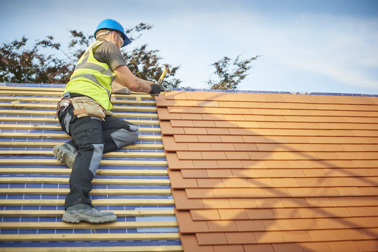 Roofer working on a clay tiled roof