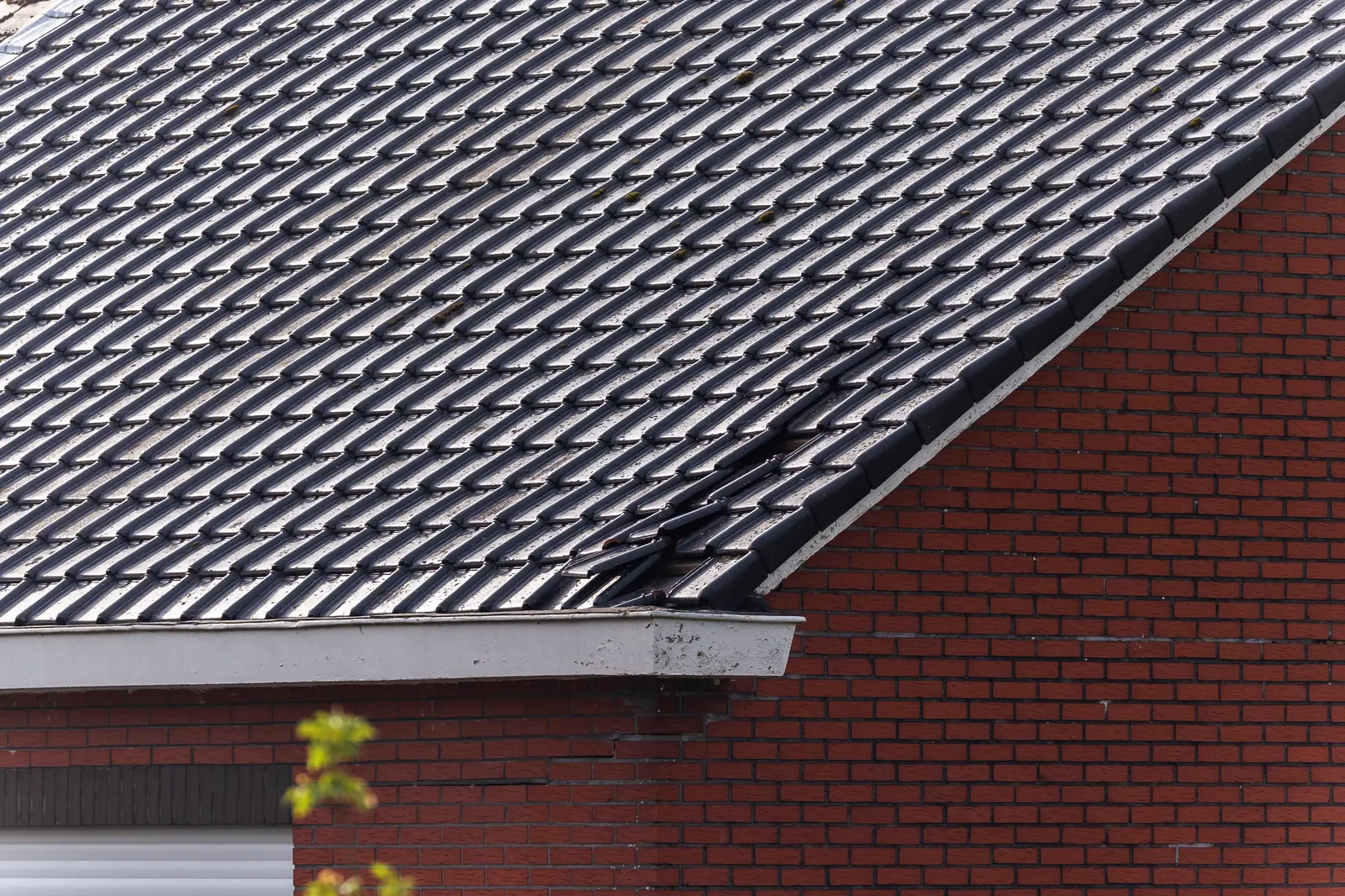 Grey tiled roof above brick walls
