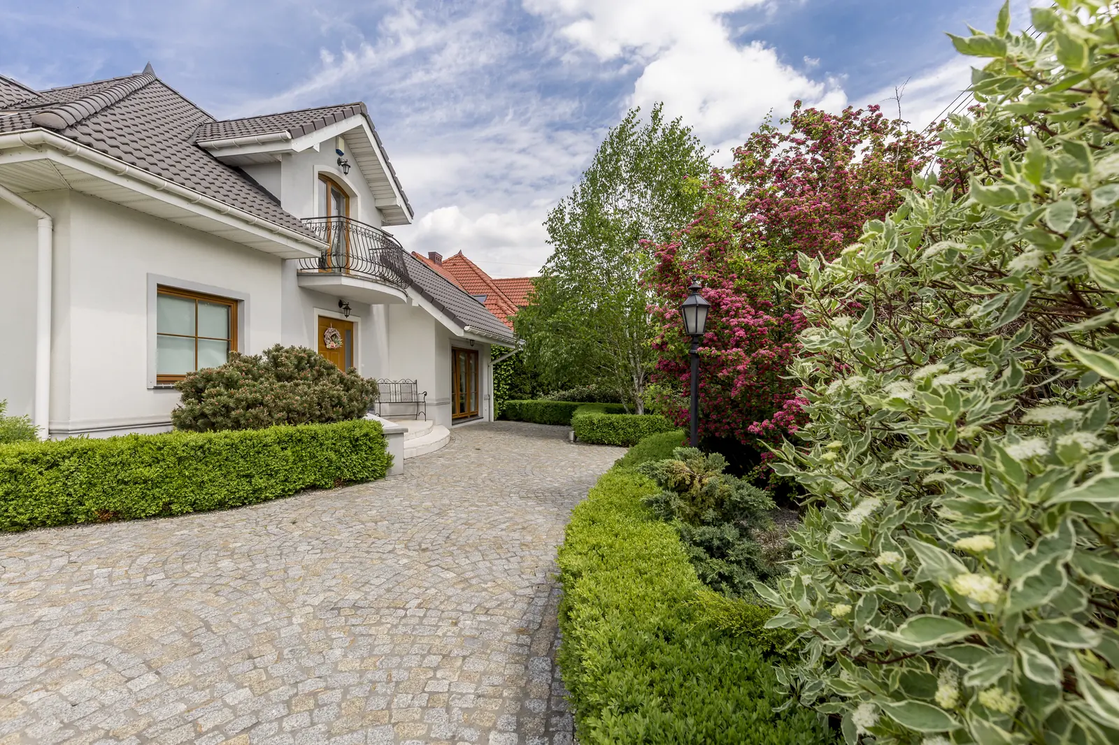 Block paved driveway curving to a house